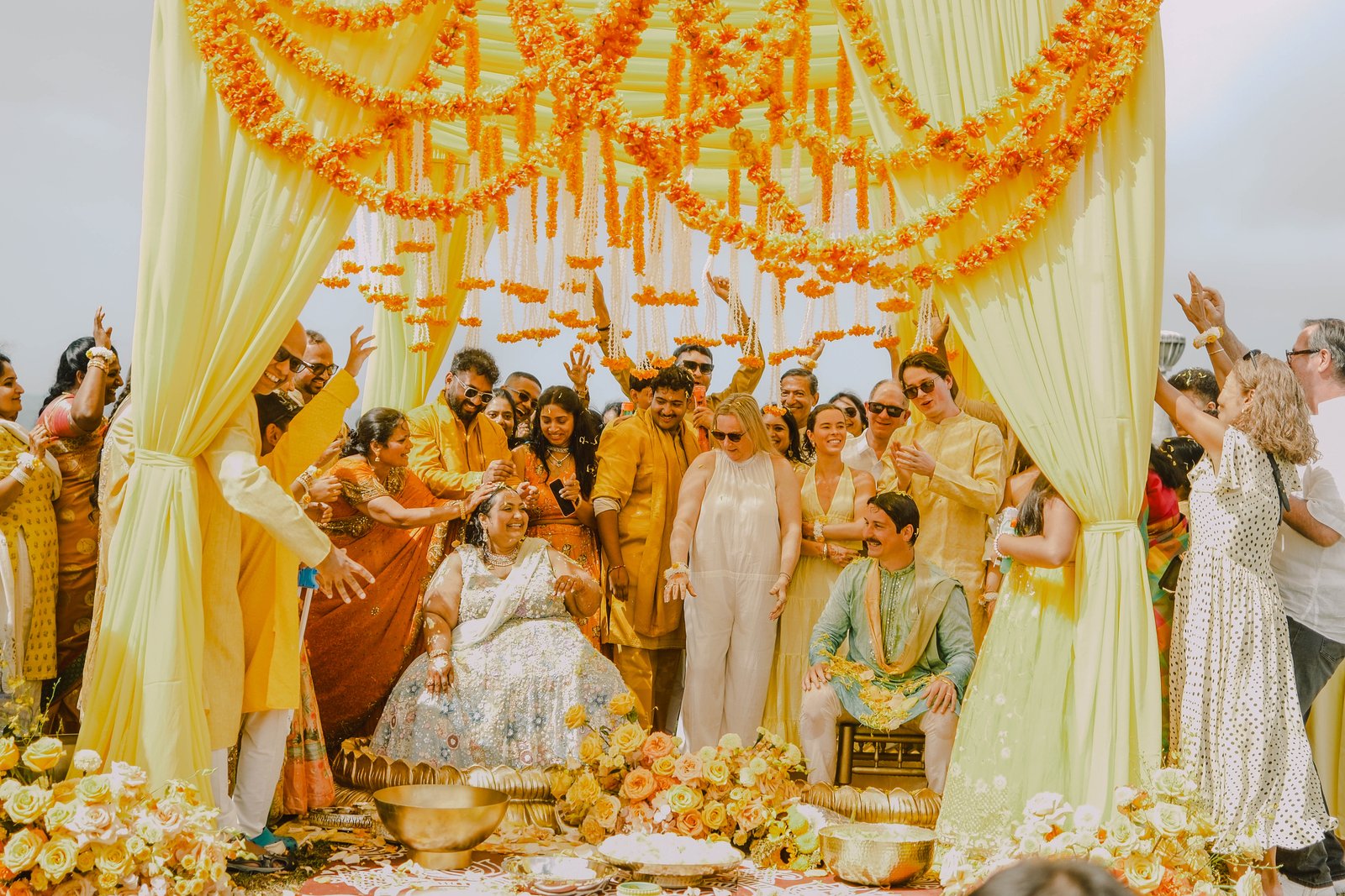 A joyful wedding celebration beneath flower garlands